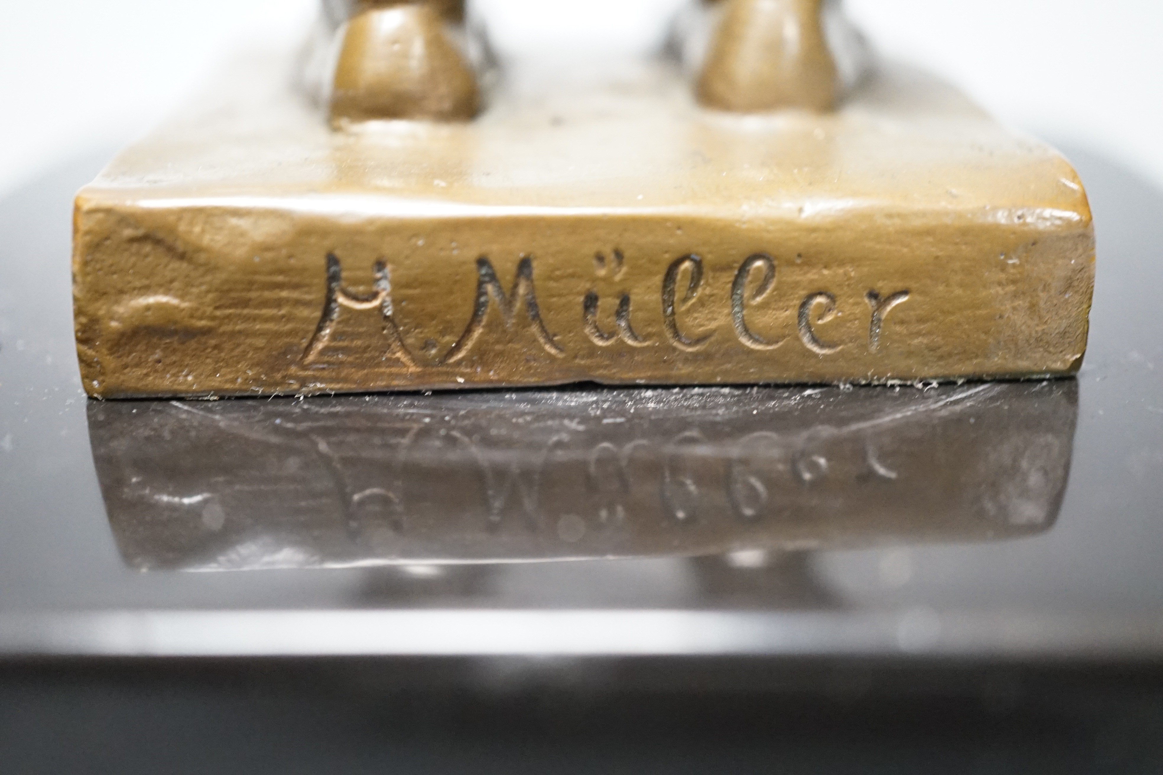 A bronze of a putto holding flowers, signed ‘M.Müller’ 25cm